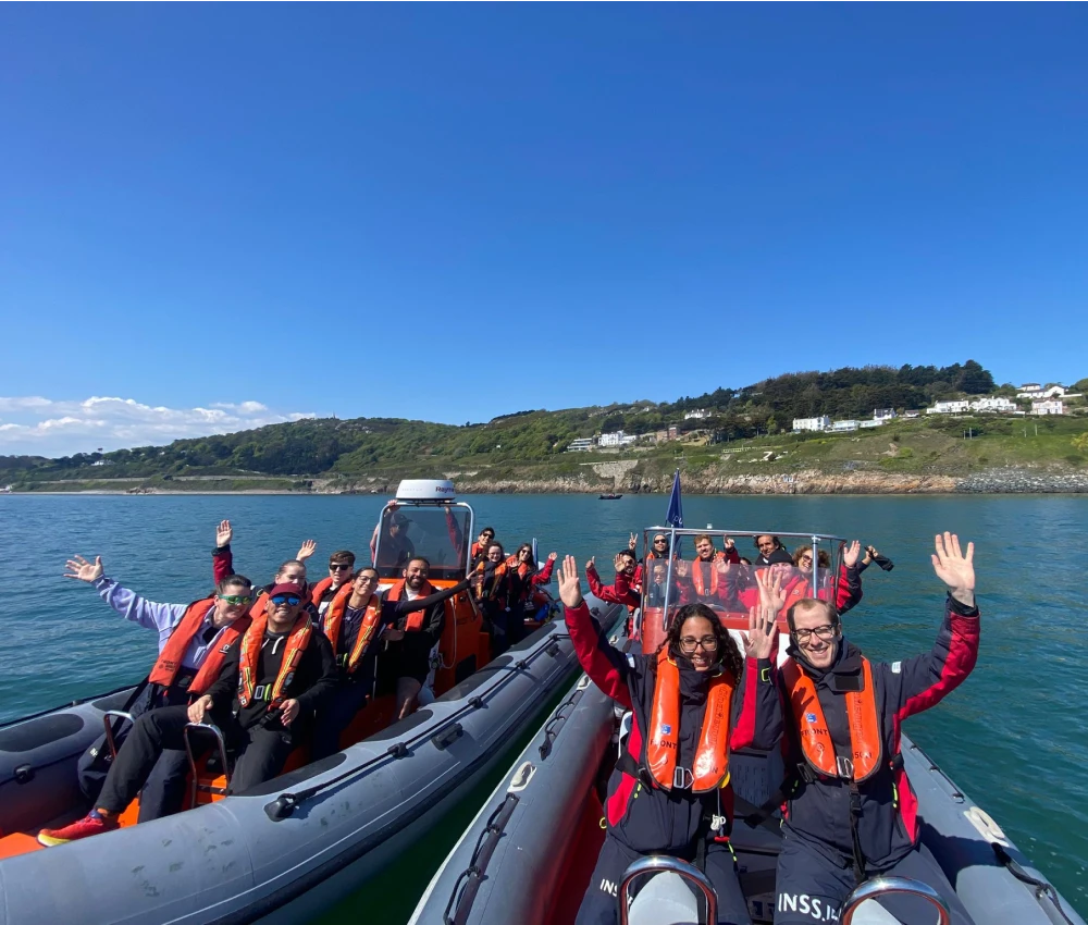 Buzz and Wasp boats cruising through Killiney Bay on a sunny day, offering scenic views of the Dublin coastline.