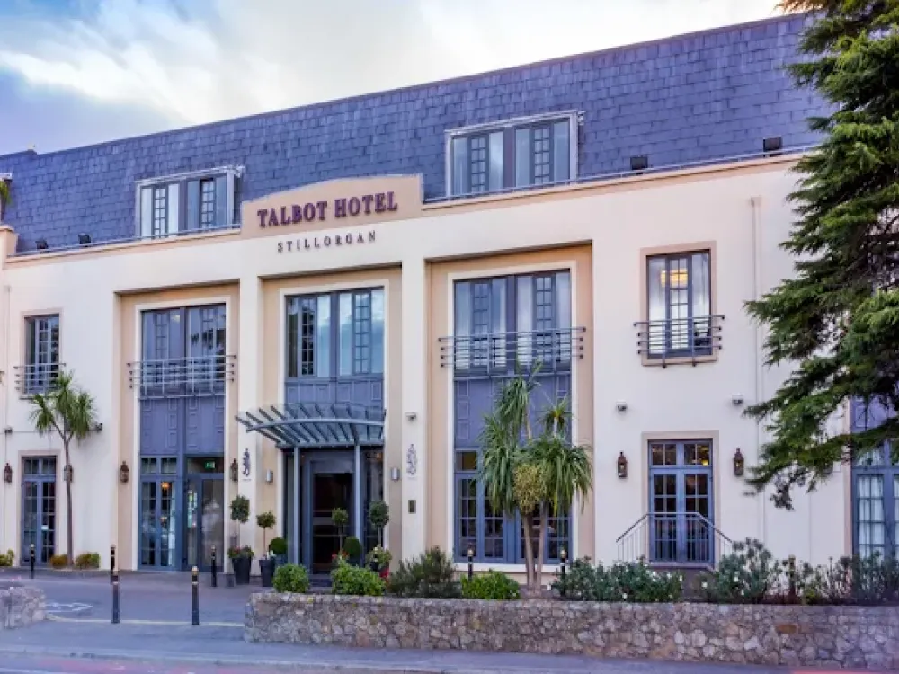Front facade of Talbot Hotel Stillorgan with modern architecture, large windows, balconies, and landscaped greenery